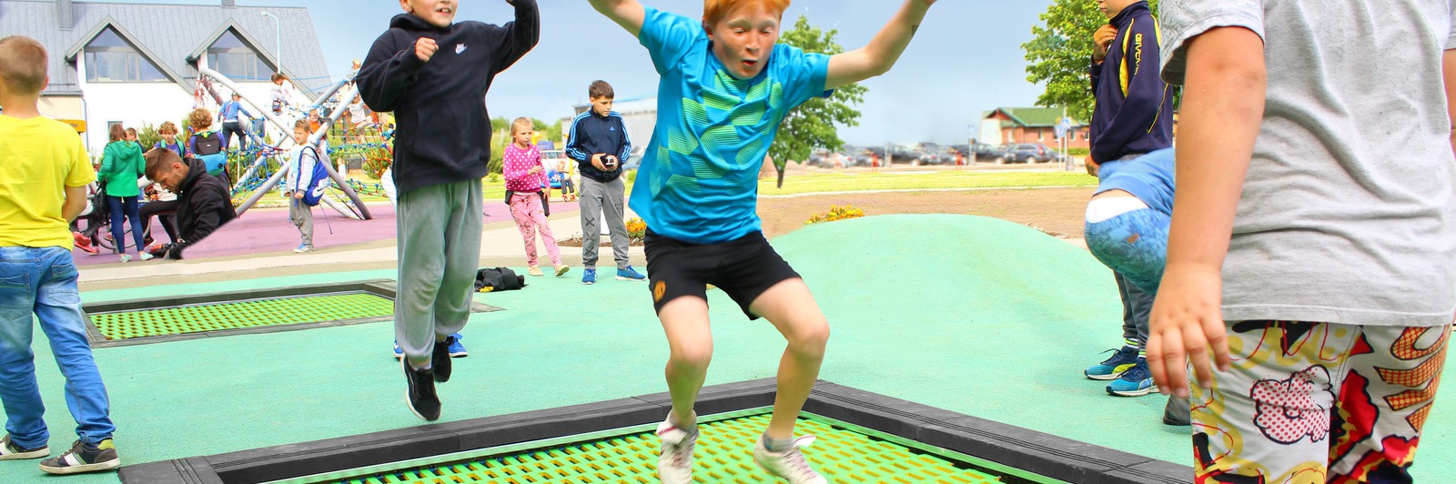 Children bouncing on a trampoline in the centre of a playground